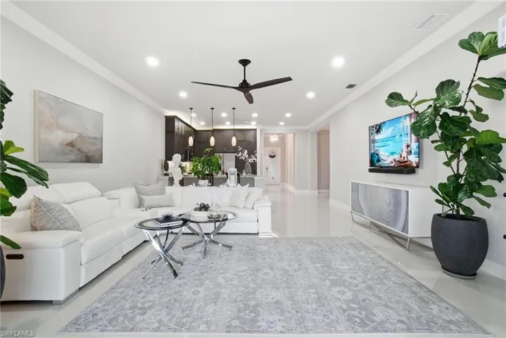 Spacious open-concept living room with crown molding, recessed lighting, and designer finishes.
