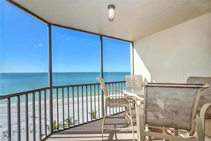 Unfurnished sunroom with a water view and a beach view