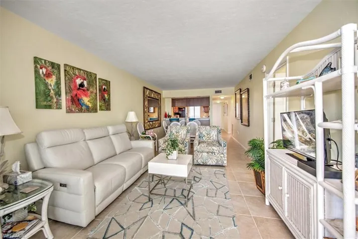 Living room featuring a textured ceiling and light tile patterned flooring