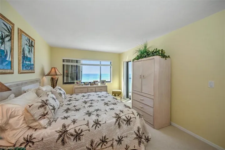 Bedroom featuring light carpet and a water view