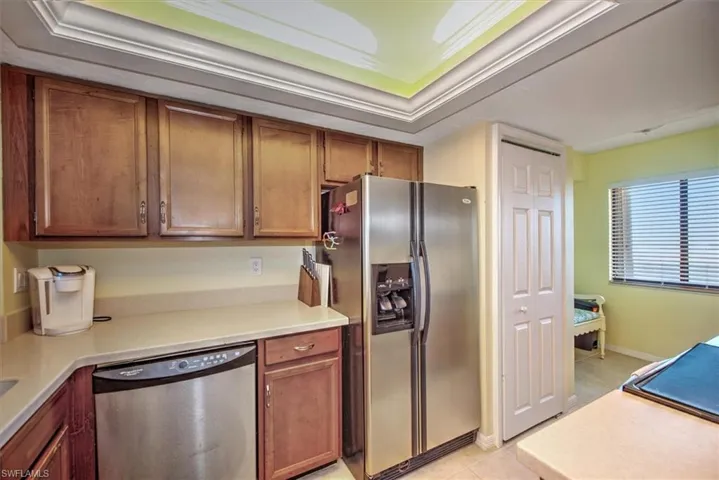 Kitchen featuring a raised ceiling, light tile patterned floors, and stainless steel appliances