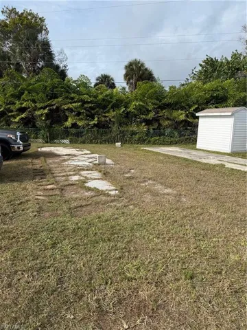 View of grassy yard featuring a storage unit
