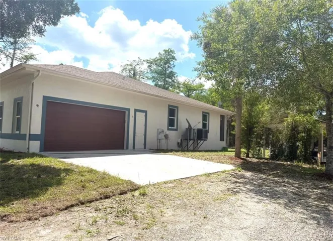 Side entry to double car garage with cement driveway
