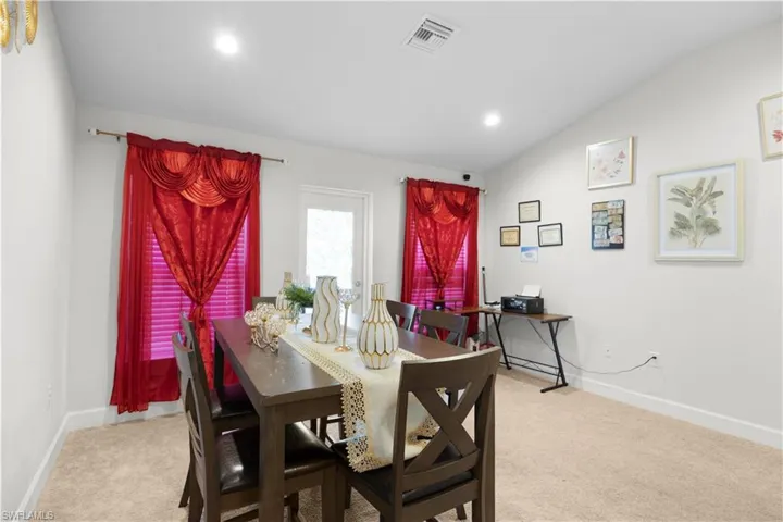 Dining room featuring vaulted ceiling, light carpet, and recessed lighting