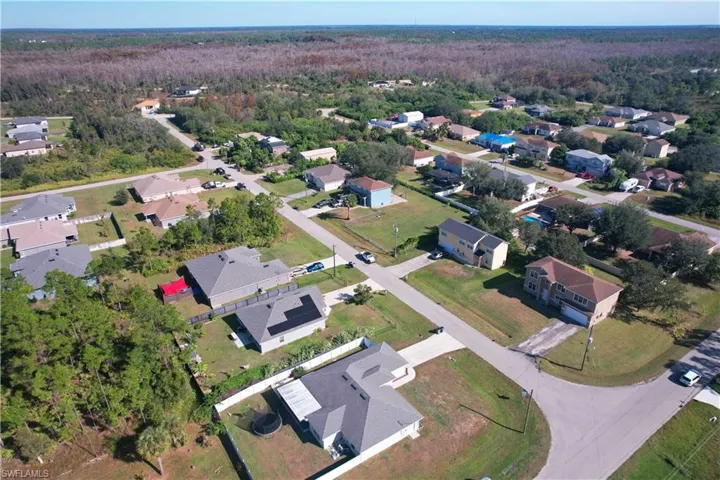 Aerial view of property and surrounding area featuring nearby suburban area