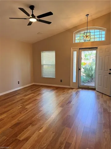 Foyer entrance with wood finished floors, lofted ceiling, and ceiling fan