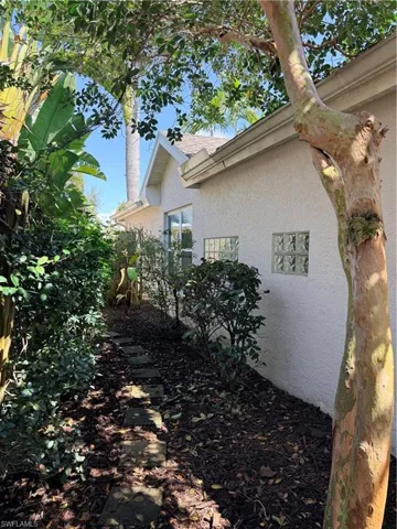 View of side of home featuring stucco siding and roof with shingles