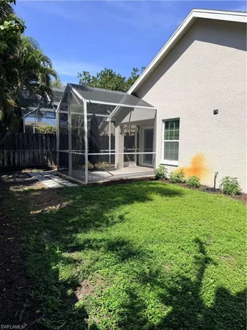 View of yard featuring screened enclosure and view of private fenced in yard