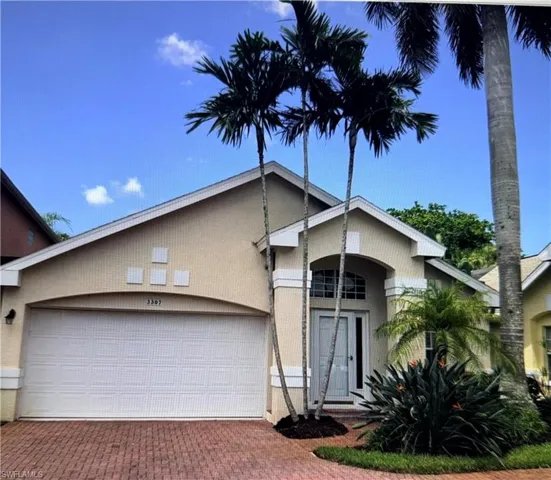 View of front of home with an attached garage and decorative driveway
