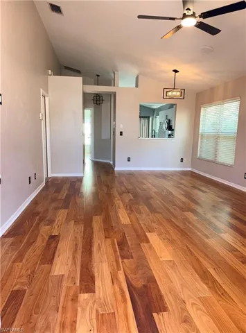 Great room with Braziian flooring,  new updated ceiling fan and chandelier in dining area