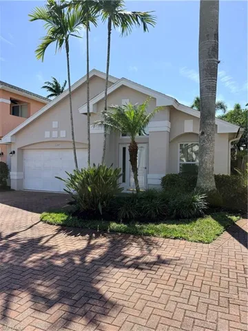 View of front of property with paver driveway, stucco siding, and an attached garage