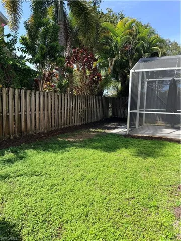 Fenced backyard featuring a lanai