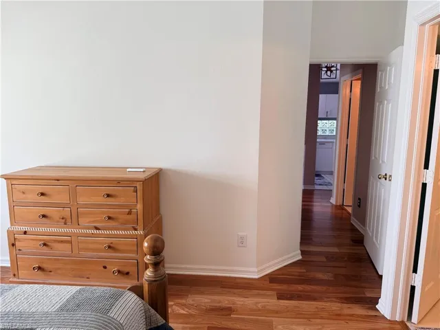 Bedroom with wood finished floors and baseboards