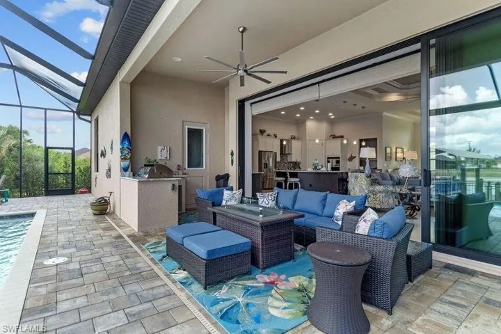 View of patio / terrace with outdoor lounge area, ceiling fan, a lanai, and exterior kitchen