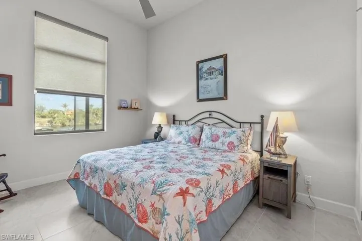 Bedroom with ceiling fan and light tile patterned flooring