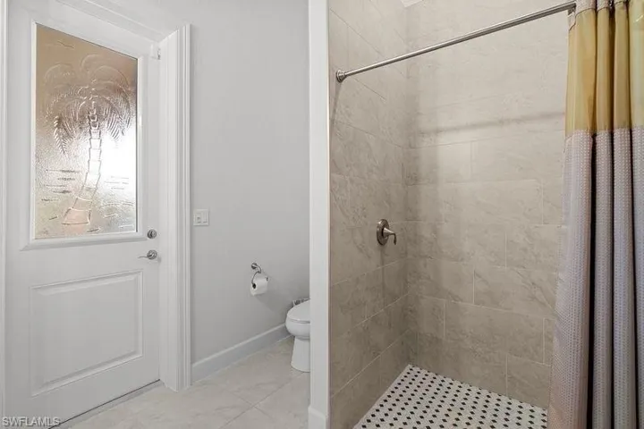 Bathroom with curtained shower and toilet