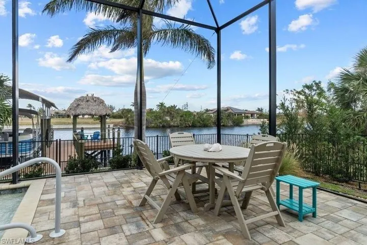 View of patio with a water view and a lanai