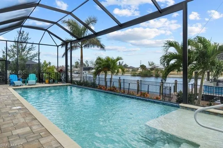 View of swimming pool with a lanai, a patio area, and a water view
