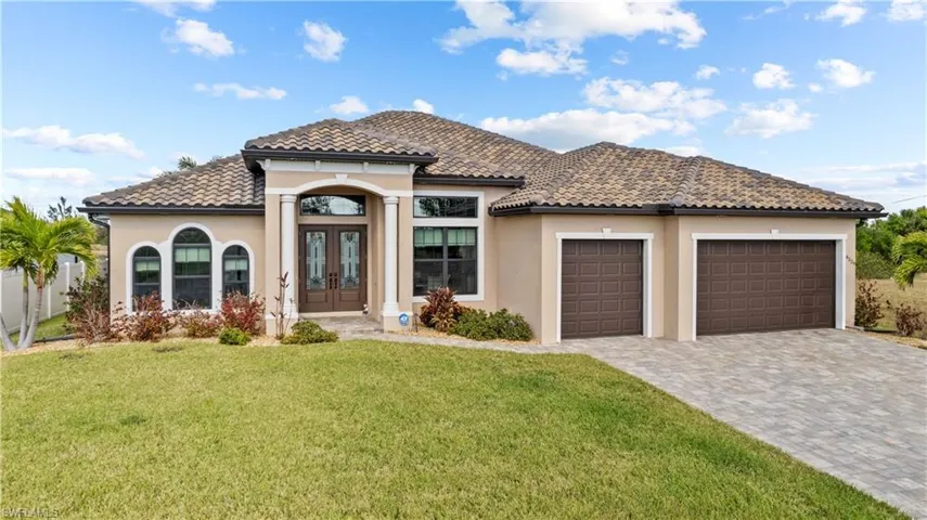 Mediterranean / spanish house featuring a front lawn, a garage, and french doors