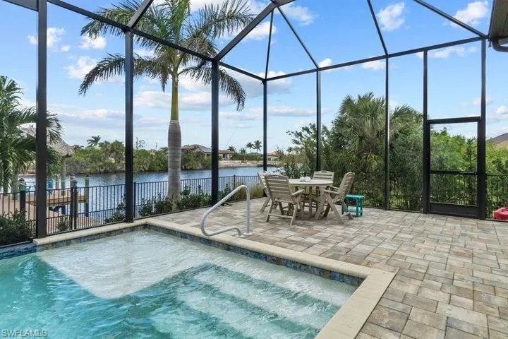 View of pool with a water view, a patio area, and a lanai