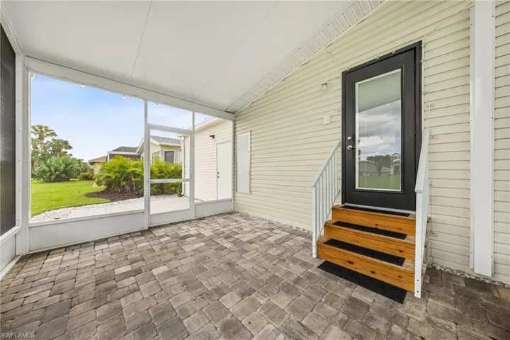 Screened lanai featuring paver flooring, a white screen enclosure, and a textured ceiling