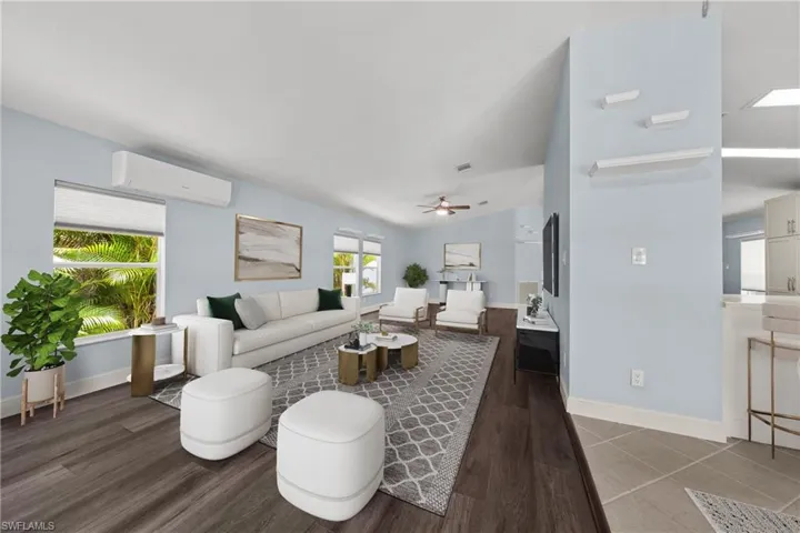 Expansive living area featuring vaulted ceilings, wood-finish flooring, and light-toned walls