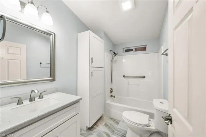 Bathroom featuring a white vanity with a light-colored countertop, an undermount sink, and a brushed nickel faucet