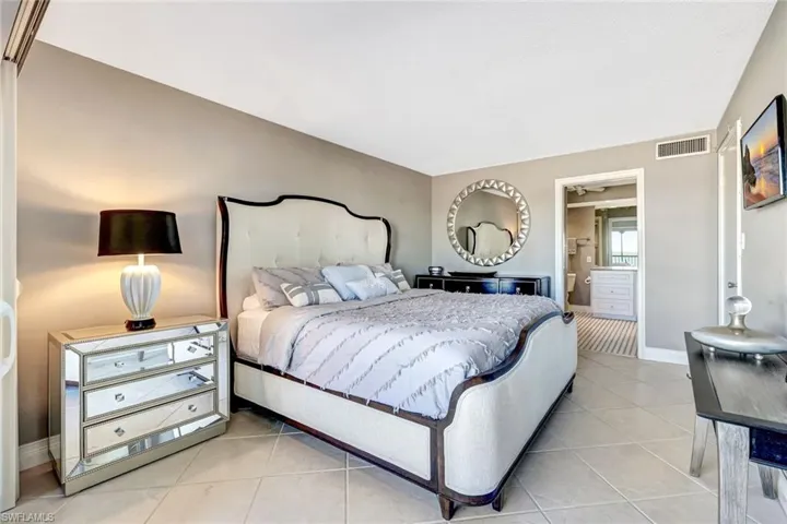 Bedroom with ensuite bathroom and light tile patterned floors