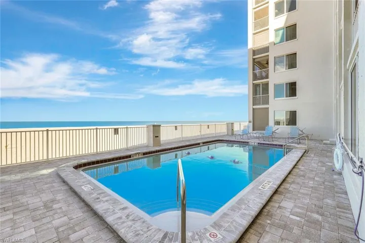 Community pool with a patio area and a water view