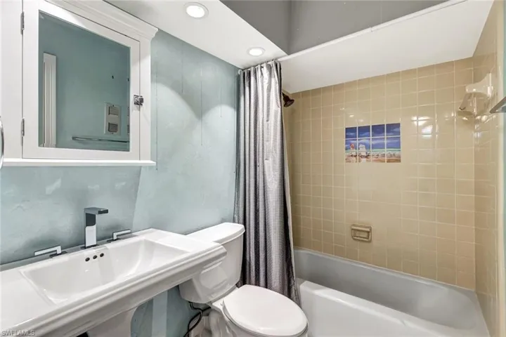 Full bathroom featuring shower / bath combination with curtain and recessed lighting