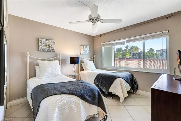 Bedroom with tile patterned floors, ceiling fan, and a textured ceiling