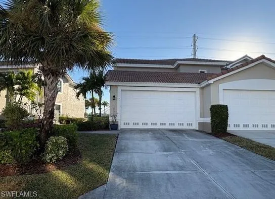 Mediterranean / spanish home featuring driveway, a tile roof, stucco siding, and an attached garage