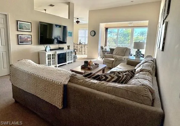 Carpeted living room with a ceiling fan