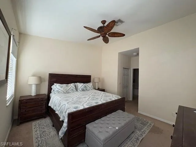 Carpeted bedroom featuring a ceiling fan and baseboards