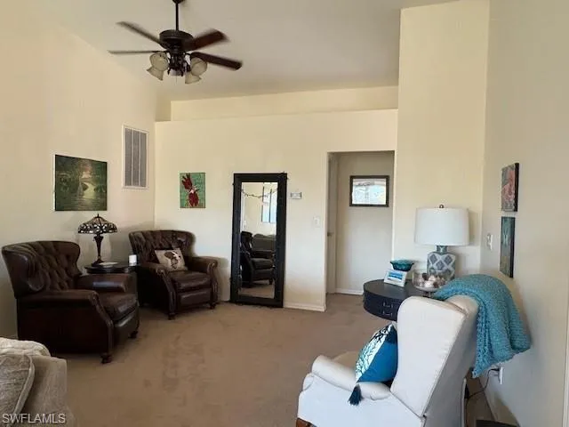Living area with carpet floors and a ceiling fan