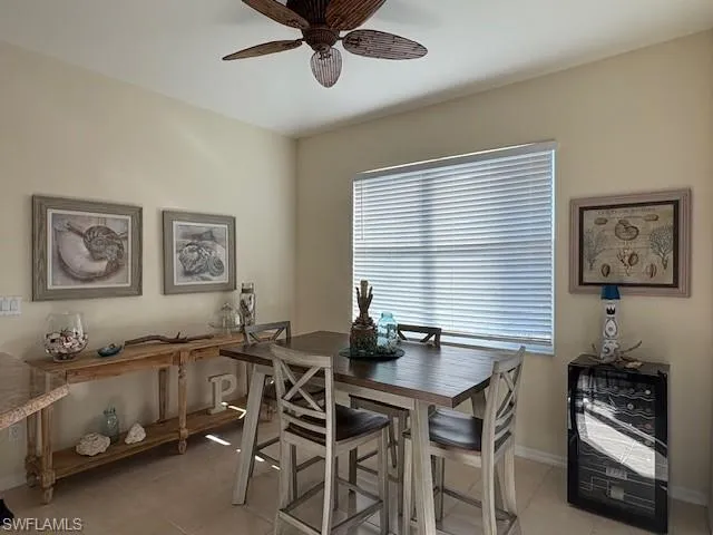 Dining space featuring light tile patterned flooring and a ceiling fan