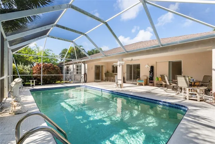 View of pool featuring ceiling fan, glass enclosure, and a patio area