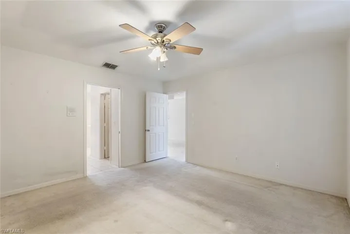 Unfurnished room featuring ceiling fan and light colored carpet