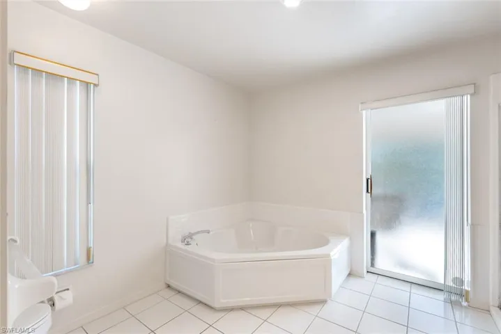 Bathroom with a tub and tile flooring