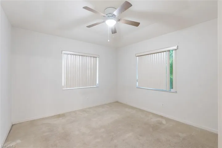 Carpeted spare room with ceiling fan