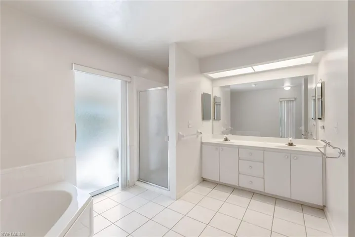 Bathroom with tile floors, plus walk in shower, and double sink vanity
