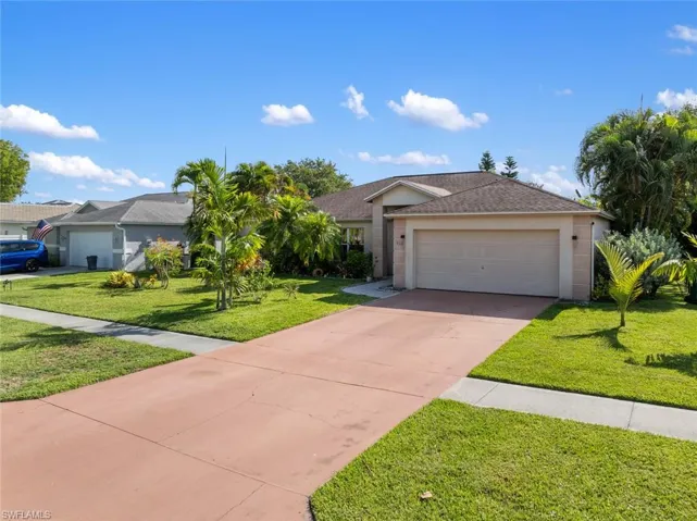 Ranch-style home with a front lawn and a garage