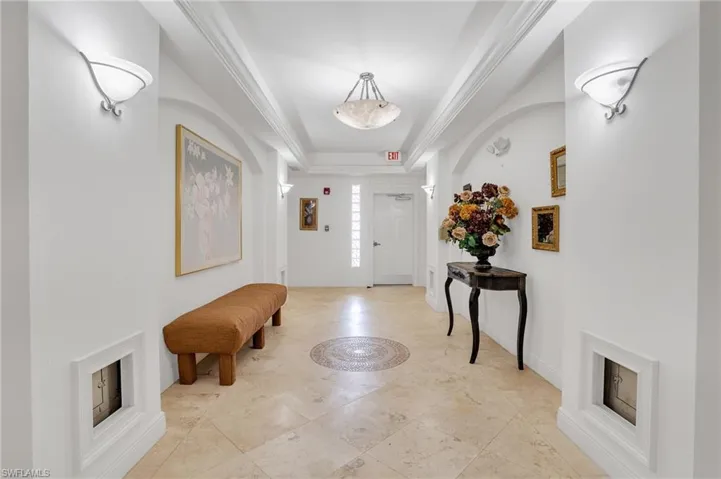 Tiled entrance foyer with crown molding and a raised ceiling