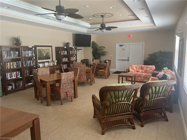 Tiled dining space featuring ceiling fan, a tray ceiling, and crown molding