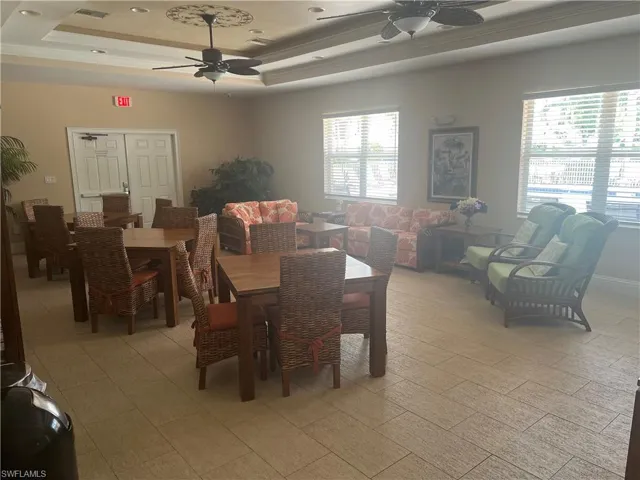 Tiled dining space featuring a tray ceiling, crown molding, and ceiling fan