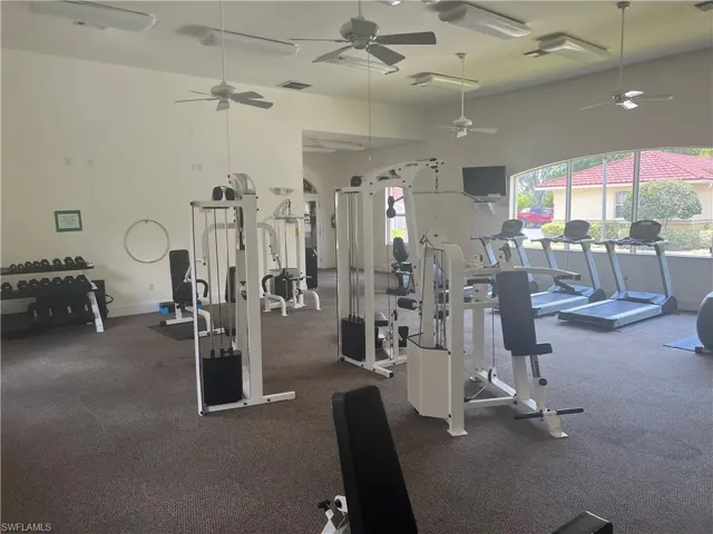 Exercise room featuring dark carpet and ceiling fan