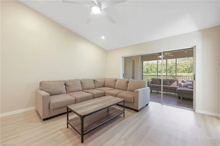Living area with a ceiling fan, vaulted ceiling, light wood finished floors, and recessed lighting