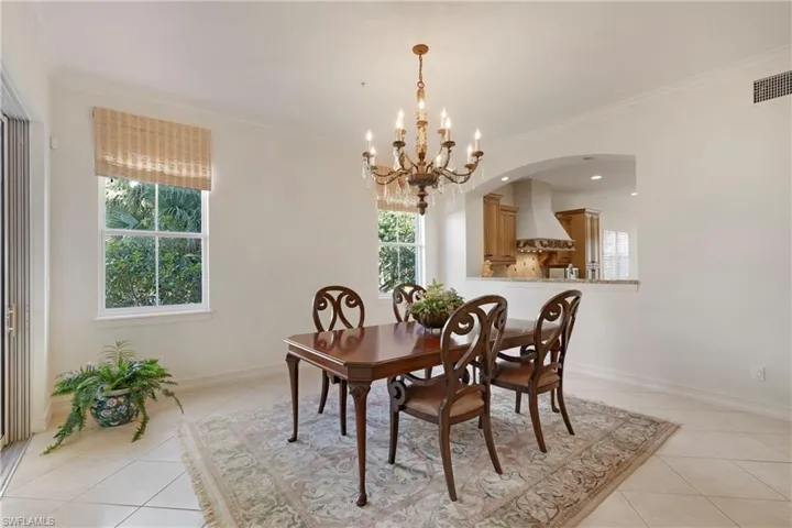 Dining area featuring a chandelier, light tile patterned floors, and crown molding