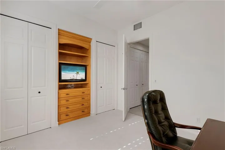 Office space featuring light tile patterned floors and built in shelves