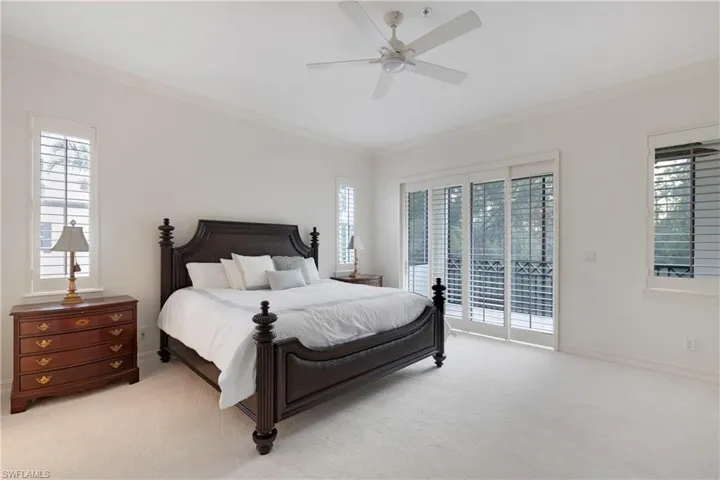 Carpeted bedroom with access to outside, ceiling fan, and crown molding